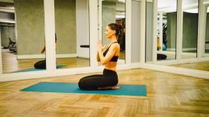 una mujer en una pose de yoga frente a un espejo en The Tillary Hotel Brooklyn en Brooklyn