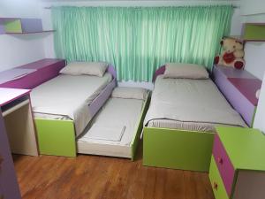duas camas num quarto com verde e roxo em Tirana Central Apartment em Tirana
