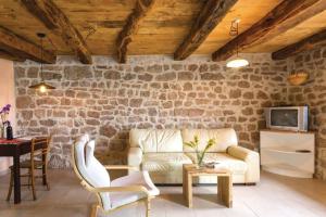 een woonkamer met een bank en een tafel bij A stone house 'Pojata' in Cista Provo