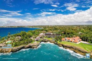 una vista aerea di una casa su un'isola rocciosa nell'oceano di Sunny Vacation Villa No 31 a Bonao