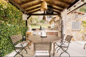 een houten tafel en stoelen op een patio bij Bastide Magdaleyna Mougins in Mougins