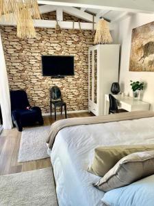 a living room with a bed and a stone wall at Bastide Magdaleyna Mougins in Mougins