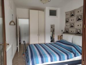 ein Schlafzimmer mit einem Bett mit einer blau-weißen gestreiften Decke in der Unterkunft CASA LACONA in Lacona