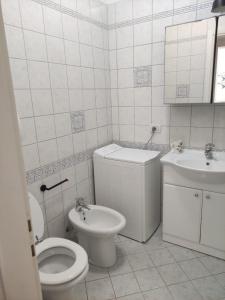 ein weißes Bad mit einem WC und einem Waschbecken in der Unterkunft CASA LACONA in Lacona