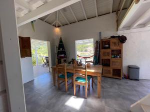 eine Küche und ein Esszimmer mit einem Holztisch und Stühlen in der Unterkunft Le Paradis créole in Terre-de-Haut