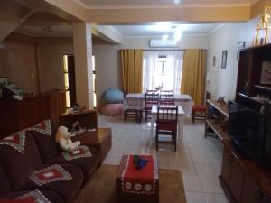 a living room with a couch and a dining room at Los Olivos in Puerto Iguazú