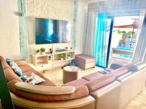 een woonkamer met een bank en een flatscreen-tv bij Mont Oreb Villas (Pearl) in Flic-en-Flac