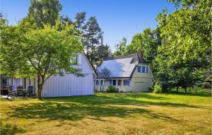 a white barn with a tree in a yard at 3 Bedroom Pet Friendly Home In Prerow in Prerow