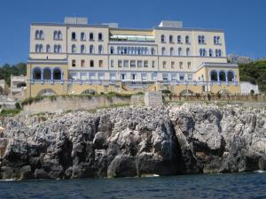 サンタ・チェザーレア・テルメにあるSea House on the rocksの水辺の崖の上にある建物