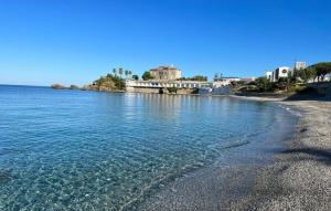 a beach with blue water and buildings in the background at La Finestrella in Belvedere Marittimo