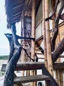 a bamboo house with a staircase and a tree at Playa Cataro Boutique Ecolodge A in Palomino