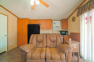 un salon avec un canapé brun dans une cuisine dans l'établissement Grand Eagle Ford Lodge & RV Park, à Nixon