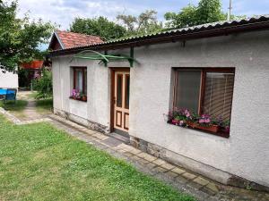 a house with two windows and flowers in a yard at Penzion Petra in Telč