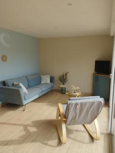 sala de estar con sofá azul y mesa en *charmant cosy entre terre et mer*, en Verton