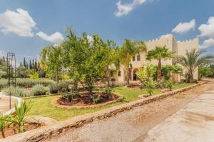 una casa con palmeras en un patio en Riad le Ksar de Fes, en Aïn Cheggag