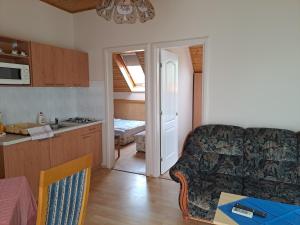 eine Küche und ein Wohnzimmer mit einem Sofa und einem Tisch in der Unterkunft Alinka Apartmanház in Balatonlelle