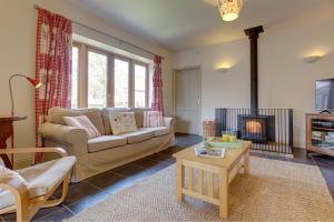 a living room with a couch and a fire place at Wash House, Rookery Farm in West Beckham