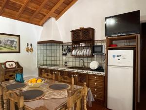una cucina con tavolo e frigorifero bianco di Casa Los Calderos a Mazo