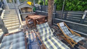 un patio con sillas, mesa, mesa y parrilla en Apartments Blazevic, heated pool&jacuzzi, en Dramalj