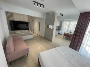 a room with a bed and a couch and a kitchen at L&C Platinum Property in Năvodari