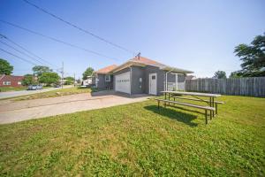 a picnic table in the grass in front of a house at Charming Erie Home about 2 Mi to Downtown Delights! in Erie