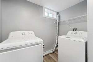 lavadero blanco con lavadora y secadora en Charming Erie Home about 2 Mi to Downtown Delights!, en Erie
