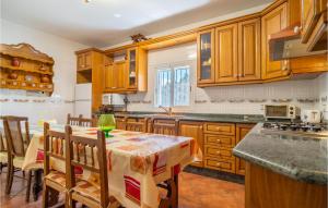 eine Küche mit Holzschränken und einem Tisch mit Stühlen in der Unterkunft 6 Bedroom Amazing Home In El Campillo in El Campillo