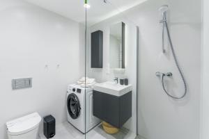 a bathroom with a washing machine and a sink at Apartament Sunrise Shellter - Rogowo in Dźwirzyno +20 photos