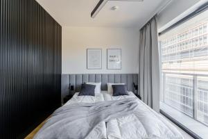 a bedroom with a large bed and a large window at Apartament Sunrise Shellter - Rogowo in Dźwirzyno