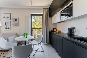 a kitchen with a table and chairs in a kitchen at Apartament Sunrise Shellter - Rogowo in Dźwirzyno