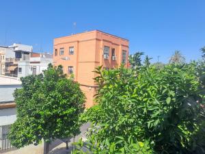 a tall brick building with trees in front of it at Casa Salma in Seville