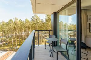 a balcony with a table and chairs on it at Apartament Sunrise Shellter - Rogowo in Dźwirzyno