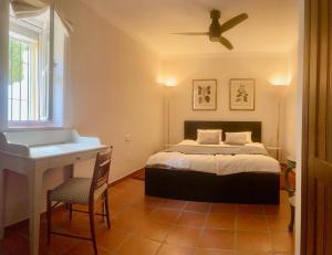 1 dormitorio con 1 cama con ventilador de techo y lavamanos en Casa Junto al Mar, en La Herradura