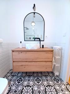 een badkamer met een houten dressoir en een spiegel bij Apartamento Marqués de Villores centro in Albacete
