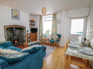 a living room with a blue couch and a fireplace at Rowan Cottage in Builth Wells