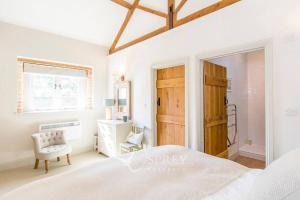 a bedroom with a bed and a chair and a window at Olive in Oundle