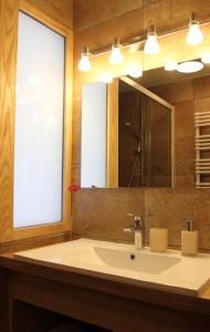 a bathroom with a sink and a large mirror at La tour Bocsozel in La Côte-Saint-André