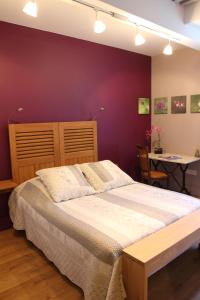 a bedroom with a large bed and a purple wall at La tour Bocsozel in La Côte-Saint-André