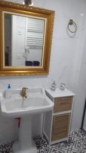 W łazience znajduje się biała umywalka i lustro. w obiekcie VOLPI MAZZO w Madrycie