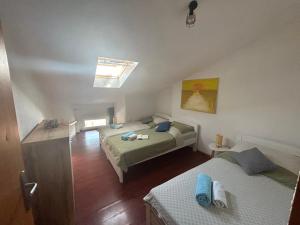 a bedroom with two beds and a skylight at Rijeka city center apartment in Rijeka