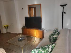 a living room with a couch and a flat screen tv at carrer de la pau port de sagunto in Valencia +9 photos