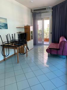 un soggiorno con tavolo e sedie su un pavimento piastrellato di Residence Myricae a Bellaria-Igea Marina