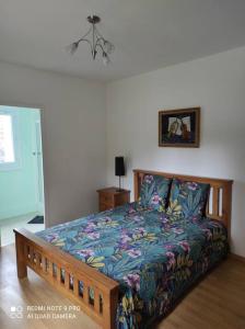 1 dormitorio con 1 cama con un edredón colorido en Cottage les hôtes Pyrénées, en Capvern