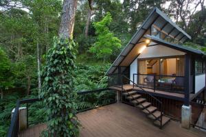 a modern house in the woods with a tree at Bamboo Dale Resort & Spa Munnar by Stride in Munnar