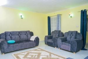 a living room with two chairs and a couch at Entire Fully furnished Villas in Kisii in Kisii