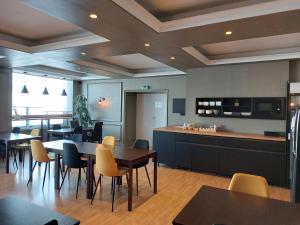 a restaurant with tables and chairs and a kitchen at Hotel l'Europe - Cholet Gare in Cholet