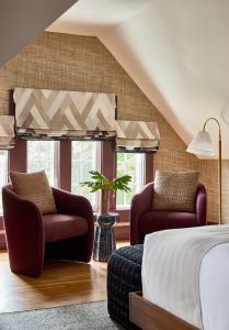a bedroom with two chairs and a bed at The Coco, The Edgartown Collection in Edgartown