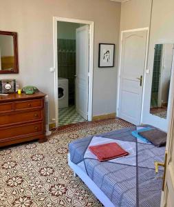 a bedroom with a bed and a dresser and a mirror at Appartement charmant centre ville in Narbonne