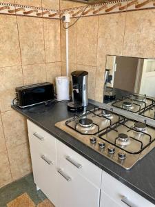 a kitchen counter with a stove top and a microwave at Appartement charmant centre ville in Narbonne