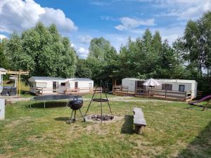 a campground with a grill and a fire pit at Pod bocianim gniazdem in Węgorzewo
